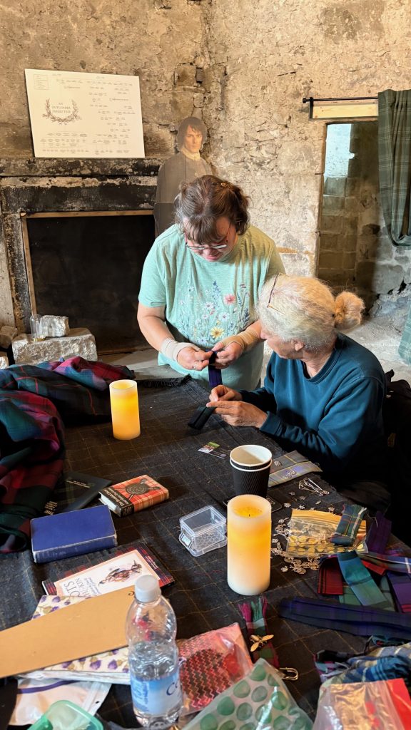 kilt workshop inside Midhope castle with a cardboard cut out of Jamie leaning against the stone wall